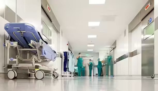 Hospital corridor with medical staff, patient bed, and modern healthcare facilities