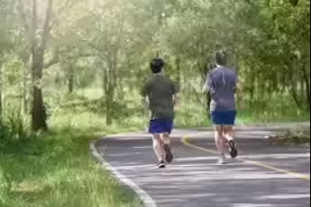 Two people jogging on a tree-lined path, representing regular physical activity and healthy lifestyle