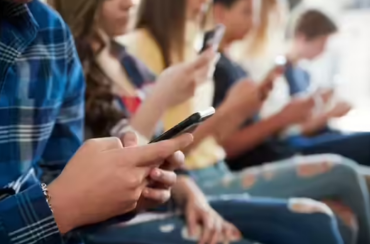 Teenagers using smartphones together, highlighting excessive screen time and digital addiction concerns