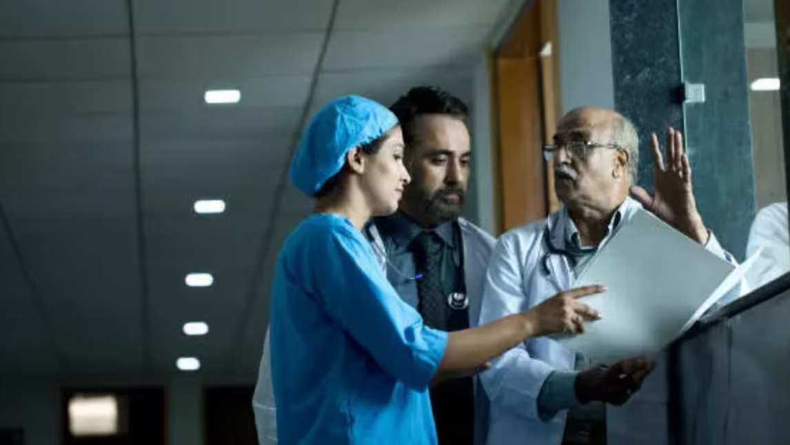 Doctors discussing patient reports in a hospital corridor highlighting workload, burnout, and challenges in India’s healthcare system