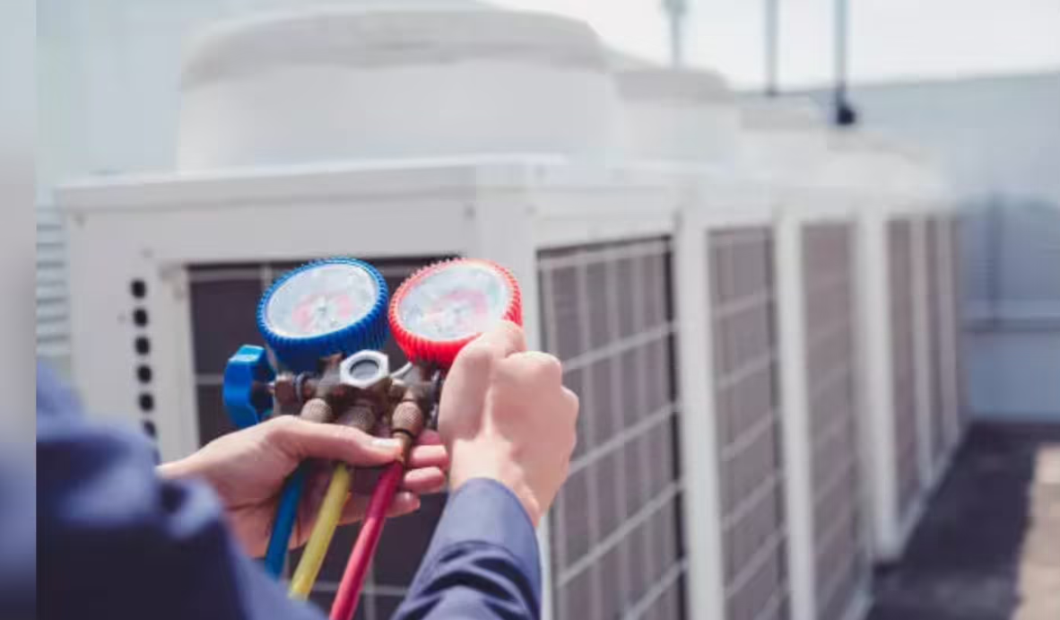 Technician checking air conditioning units with pressure gauges highlighting access to cooling and climate adaptation needs
