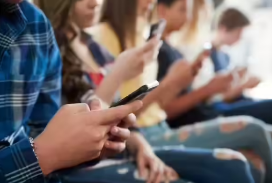 Teenagers using smartphones and social media apps highlighting concerns over digital addiction and online safety for children