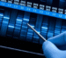 DNA sequencing analysis in a laboratory showing genetic data bands with a researcher examining results using a probe