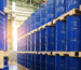 Stacked blue industrial barrels storing petrochemical materials in a warehouse for pharma and manufacturing supply chains