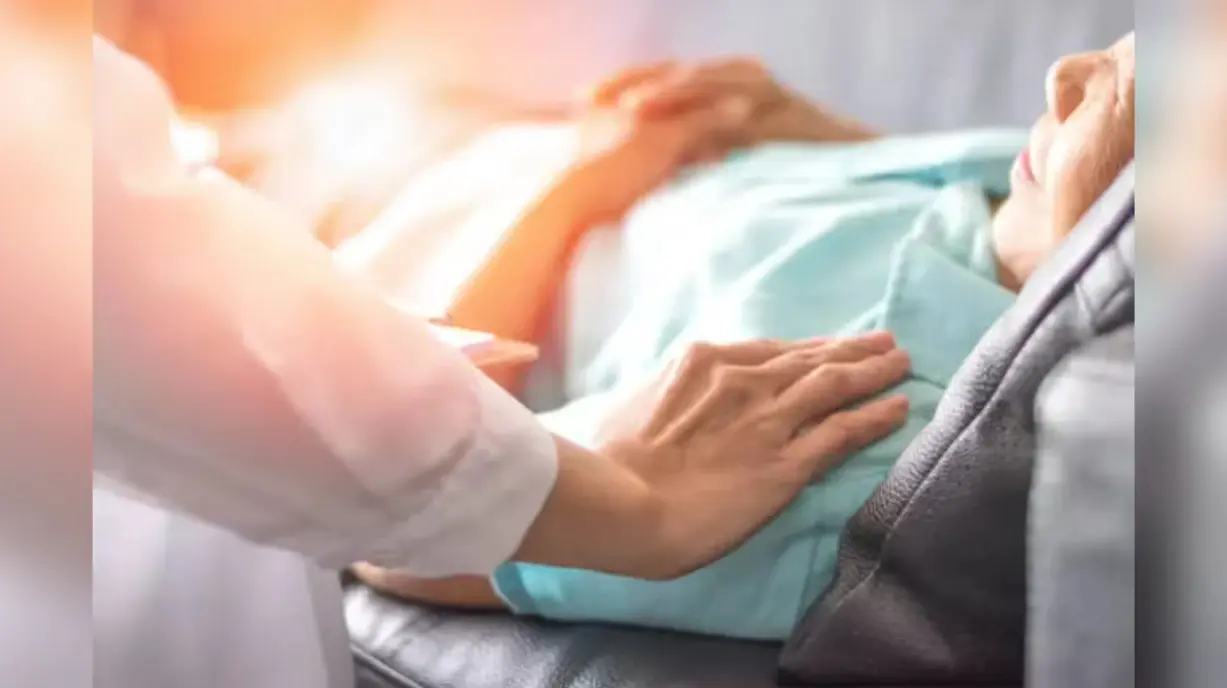 Doctor providing palliative care to elderly patient in hospital bed showing compassionate end of life support and healthcare services