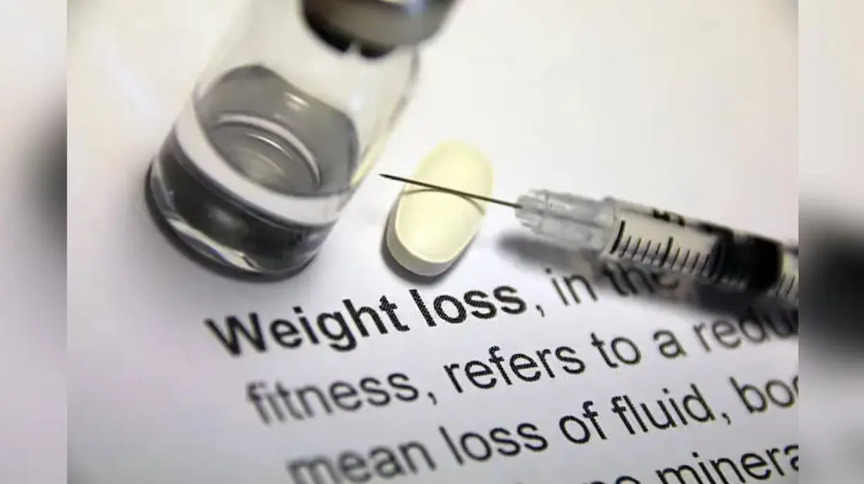 Weight loss medication, syringe and tablet representing GLP-1 obesity treatment and appetite control drugs