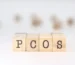 PCOS awareness concept image showing wooden blocks spelling PCOS representing hormonal disorder and infertility issues in women